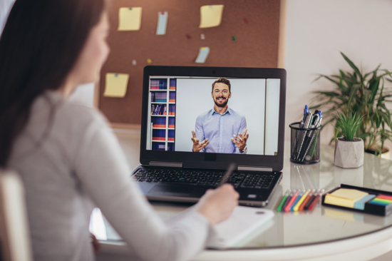 a photo of a man presenting training on a laptop screen with a woman watching
