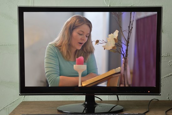 Woman seen through a computer monitor